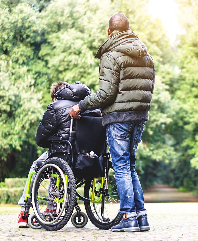 Pflegekreuz GmbH – Pflegekraft hilft einer Person im Rollstuhl